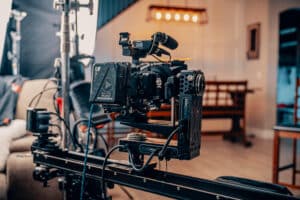 Professional video camera mounted on a motorized slider with lighting equipment in indoor setting